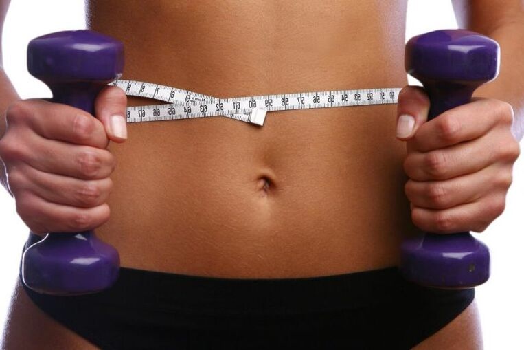 Gantere de fitness în mâinile unei fete potrivite